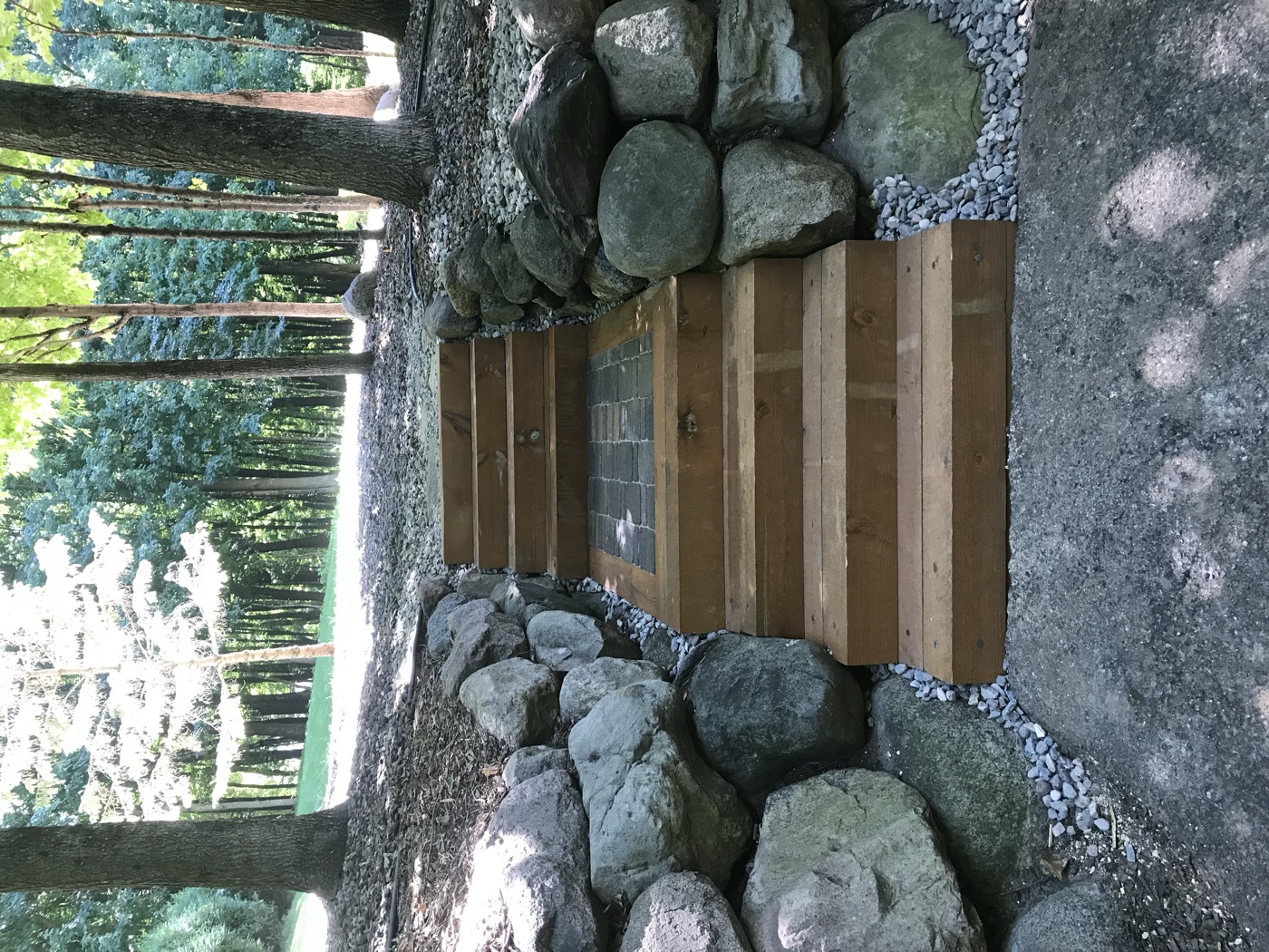 Timber steps flanked by a natural boulder retaining wall