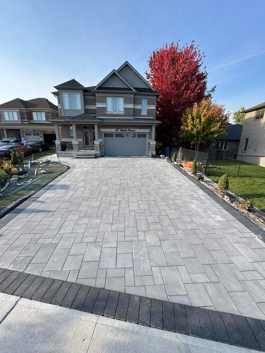 Wide paver driveway with clean borders leading to a home
